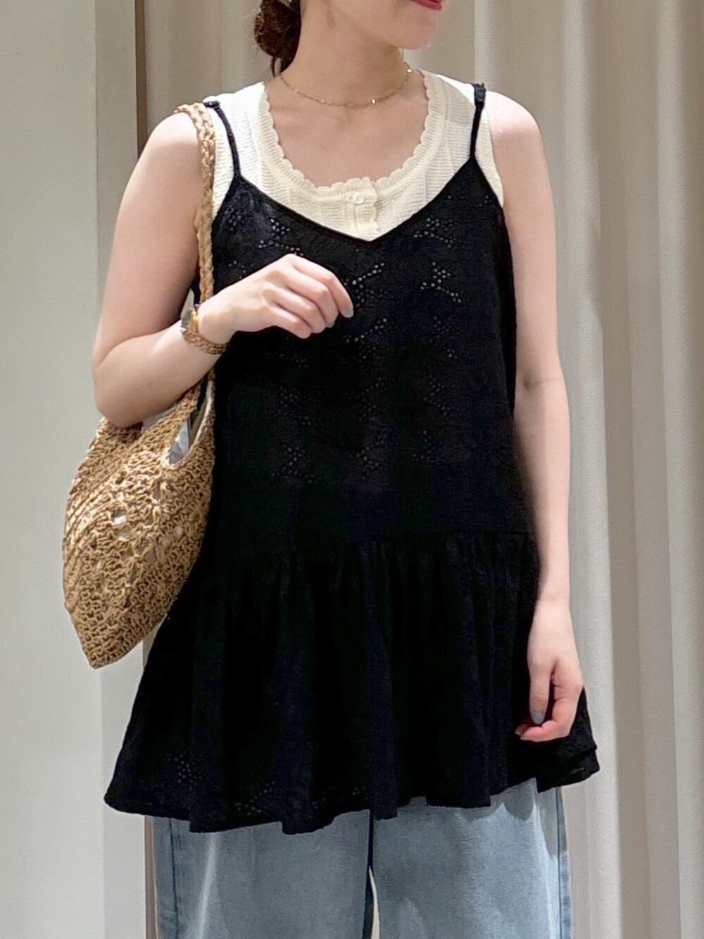 ブラック系のシャツ/ブラウス、ホワイト系のニット/セーター、ベージュ系のトートバッグを着用したレディースの春コーディネートの4枚目の写真