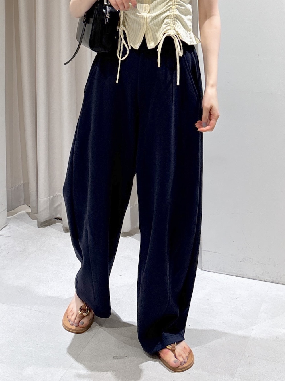 イエロー系のシャツ/ブラウス、ブルー系のその他パンツ、ブラック系のショルダーバッグを着用したレディースの夏コーディネートの3枚目の写真