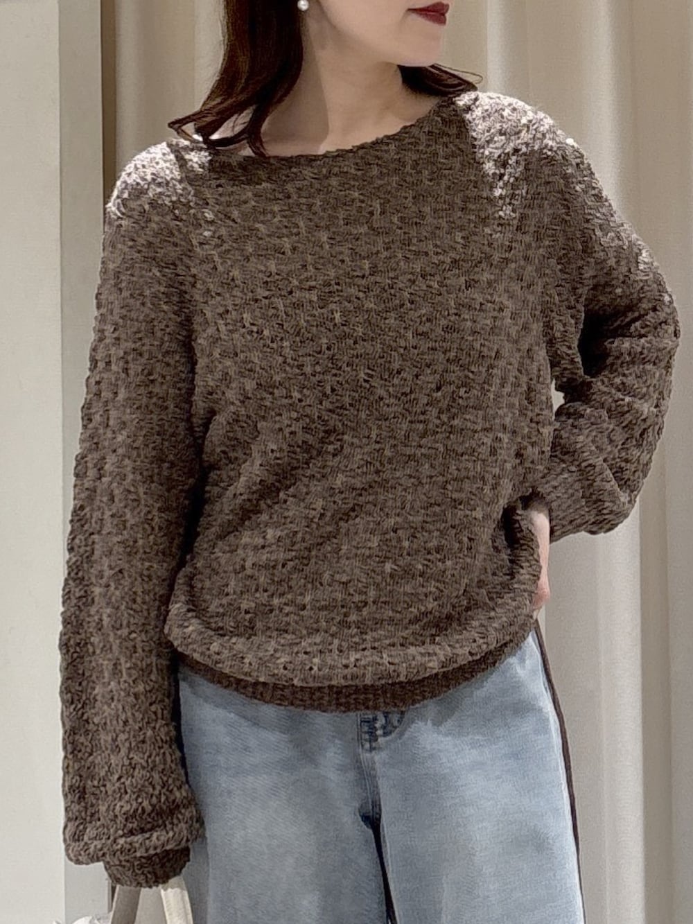 ブラウン系のニット/セーター、ホワイト系のショルダーバッグ、ブルー系のデニムパンツを着用したレディースの冬コーディネートの4枚目の写真