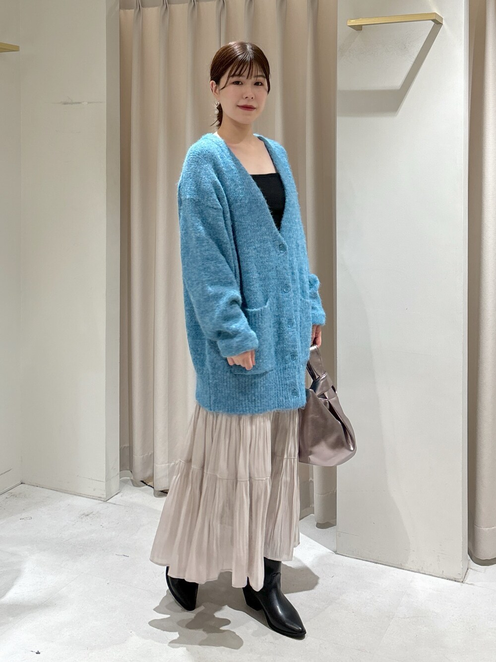 ブルー系のカーディガン/ボレロ、ブラック系のキャミソール、ホワイト系のスカートを着用したレディースの秋コーディネートの9枚目の写真