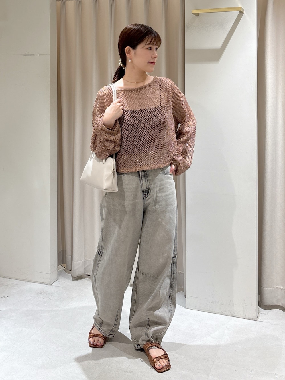 ブラウン系のニット/セーター、ブラック系のキャミソール、グレー系のデニムパンツを着用したレディースの秋コーディネートの5枚目の写真