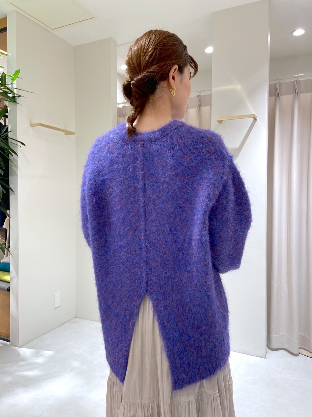 ブルー系のニット/セーター、ベージュ系のショルダーバッグ、ブラック系のブーツを着用したレディースの秋コーディネートの4枚目の写真