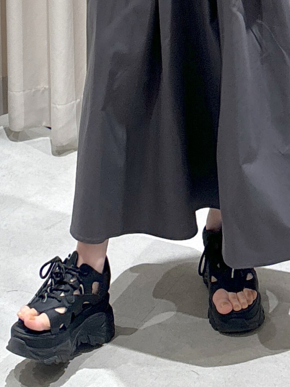 ブルー系のカーディガン/ボレロ、ホワイト系のタンクトップ、グレー系のスカートを着用したレディースの春コーディネートの4枚目の写真