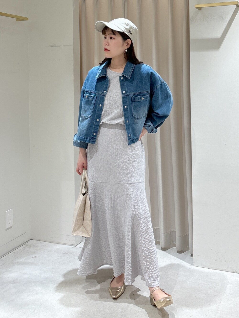 ブルー系のブルゾン、グレー系のワンピース、ホワイト系のトートバッグを着用したレディースの春コーディネートの2枚目の写真