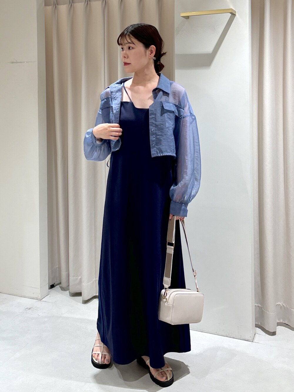 ブルー系のシャツ/ブラウス、ブルー系のワンピース、ホワイト系のボディバッグ/ウエストポーチを着用したレディースの夏コーディネートの3枚目の写真