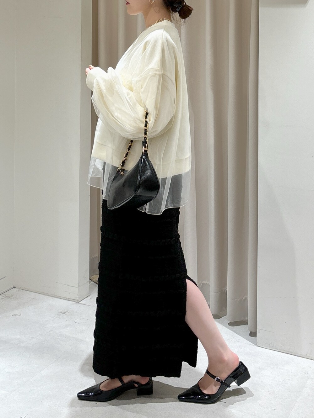 ホワイト系のスウェット、ブラック系のスカート、ブラック系のトートバッグを着用したレディースの秋コーディネートの4枚目の写真