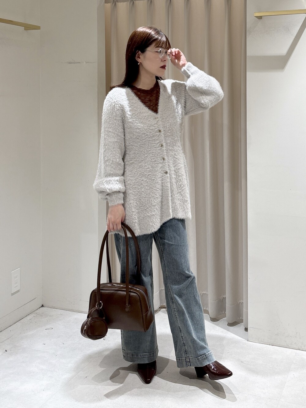 グレー系のニット/セーター、ブラウン系のTシャツ/カットソー、ブラウン系のトートバッグを着用したレディースの秋コーディネートの7枚目の写真