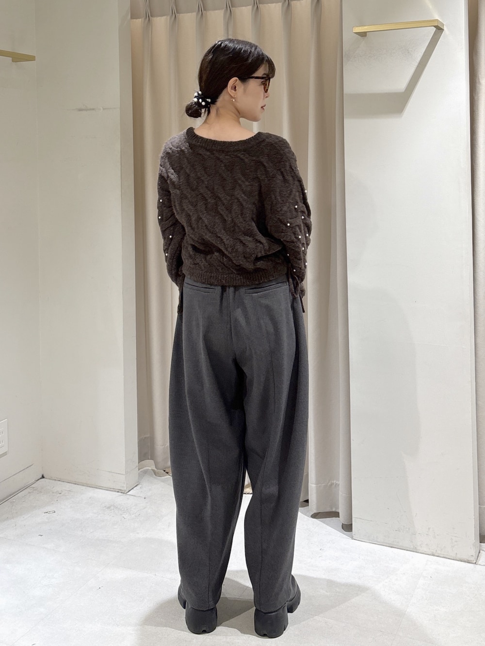 ブラウン系のニット/セーター、グレー系のその他パンツ、ブラウン系のハンドバッグを着用したレディースの冬コーディネートの5枚目の写真