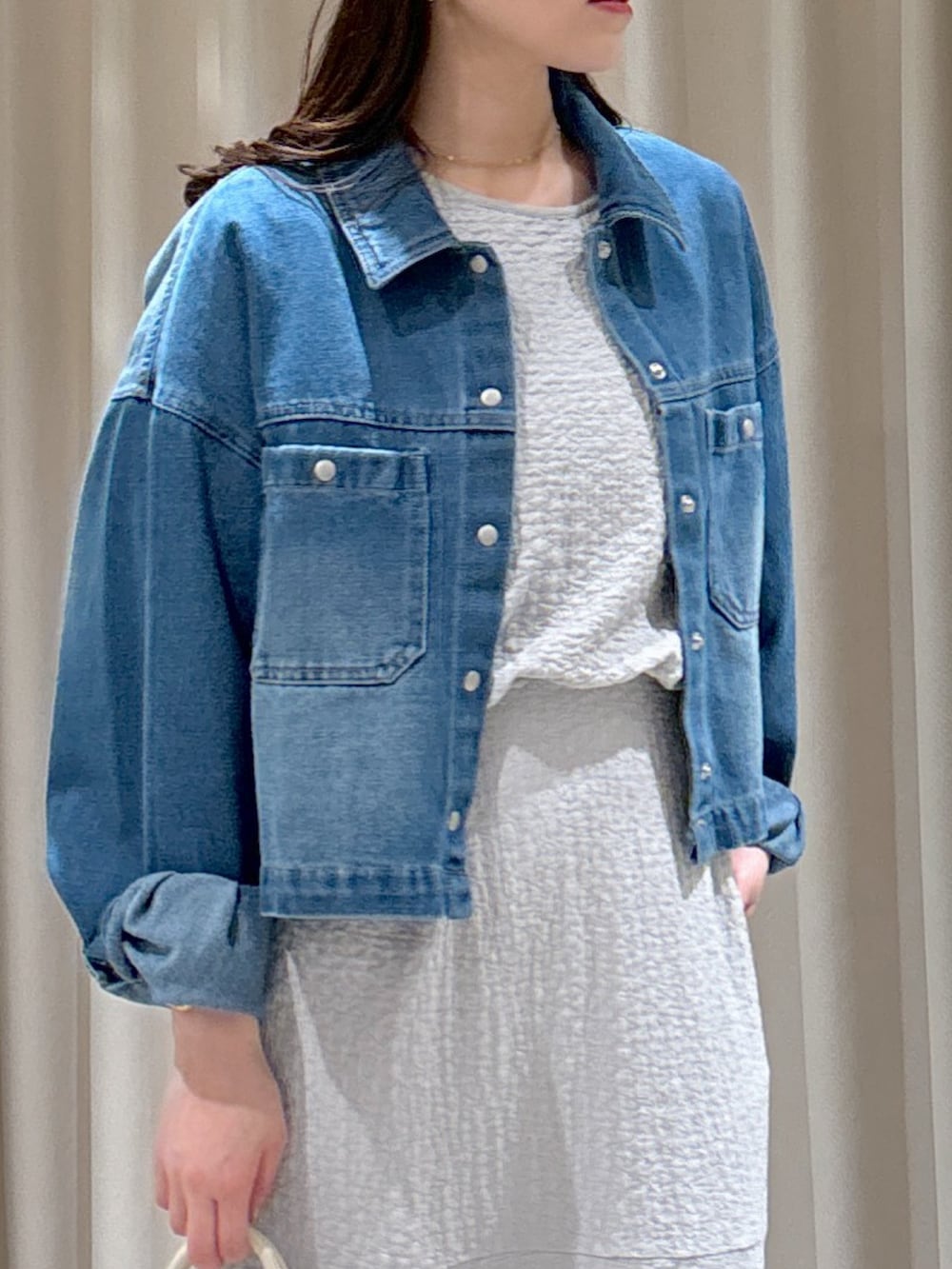 ブルー系のブルゾン、グレー系のワンピース、ホワイト系のトートバッグを着用したレディースの春コーディネートの4枚目の写真