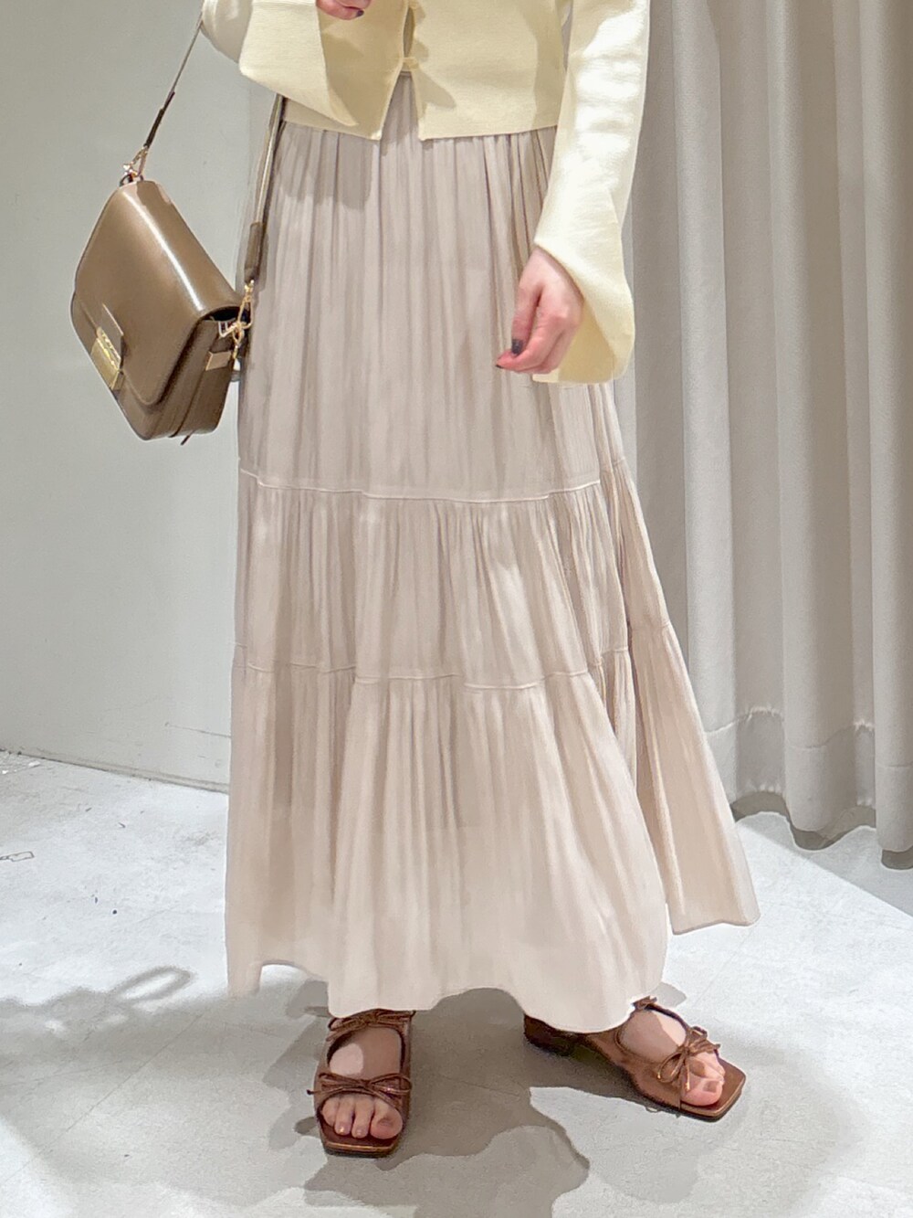 ホワイト系のニット/セーター、ベージュ系のショルダーバッグ、ホワイト系のスカートを着用したレディースの春コーディネートの3枚目の写真