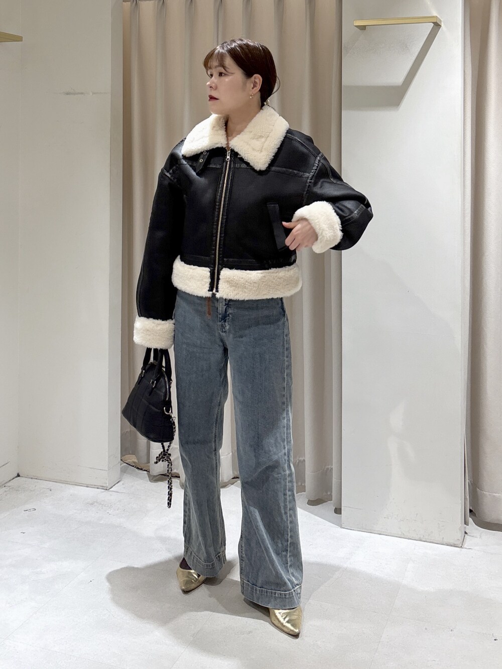 ブラウン系のニット/セーター、ブルー系のデニムパンツ、ブラック系のトートバッグを着用したレディースの秋コーディネートの5枚目の写真