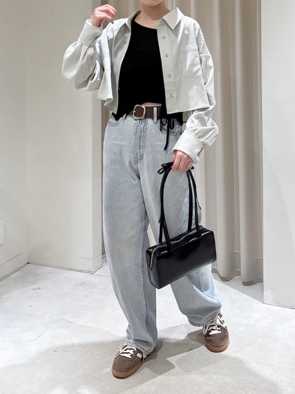 グレー系のシャツ/ブラウス、ブラック系のTシャツ/カットソー、ブルー系のデニムパンツを着用したレディースの春コーディネートの2枚目の写真