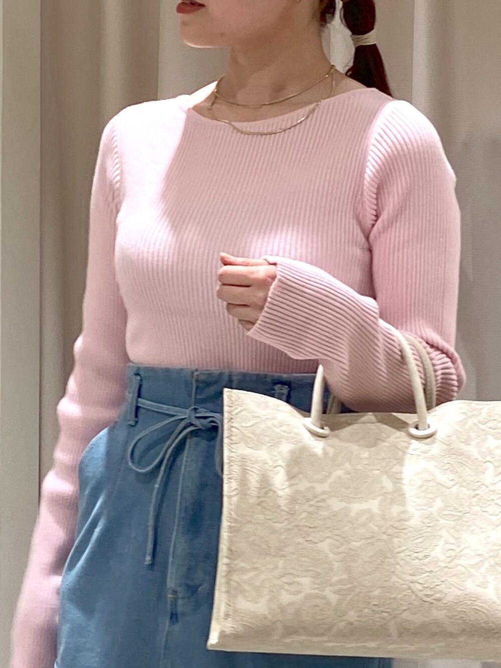 ブルー系のデニムスカート、ホワイト系のトートバッグ、シルバー系のパンプスを着用したレディースの冬コーディネートの4枚目の写真