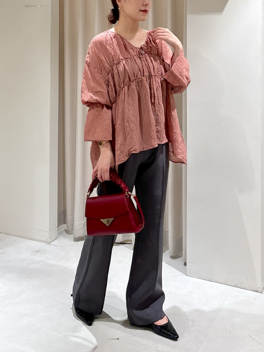 ブラック系のシャツ/ブラウス、レッド系のショルダーバッグ、グレー系のスラックスを着用したレディースの秋コーディネートの6枚目の写真