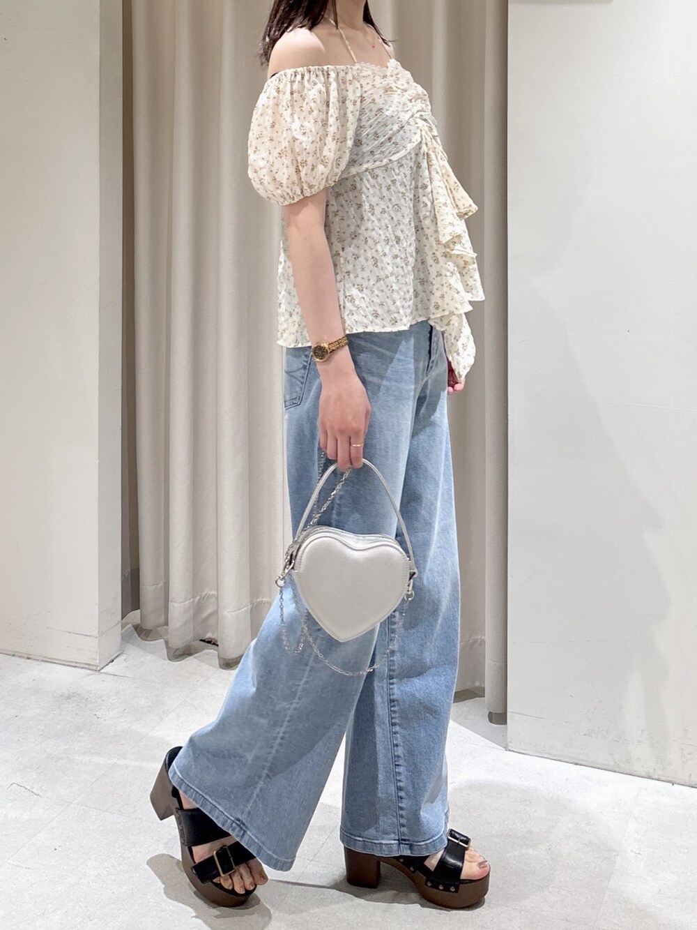 ホワイト系のシャツ/ブラウス、シルバー系のショルダーバッグ、ブルー系のデニムパンツを着用したレディースの春コーディネートの2枚目の写真