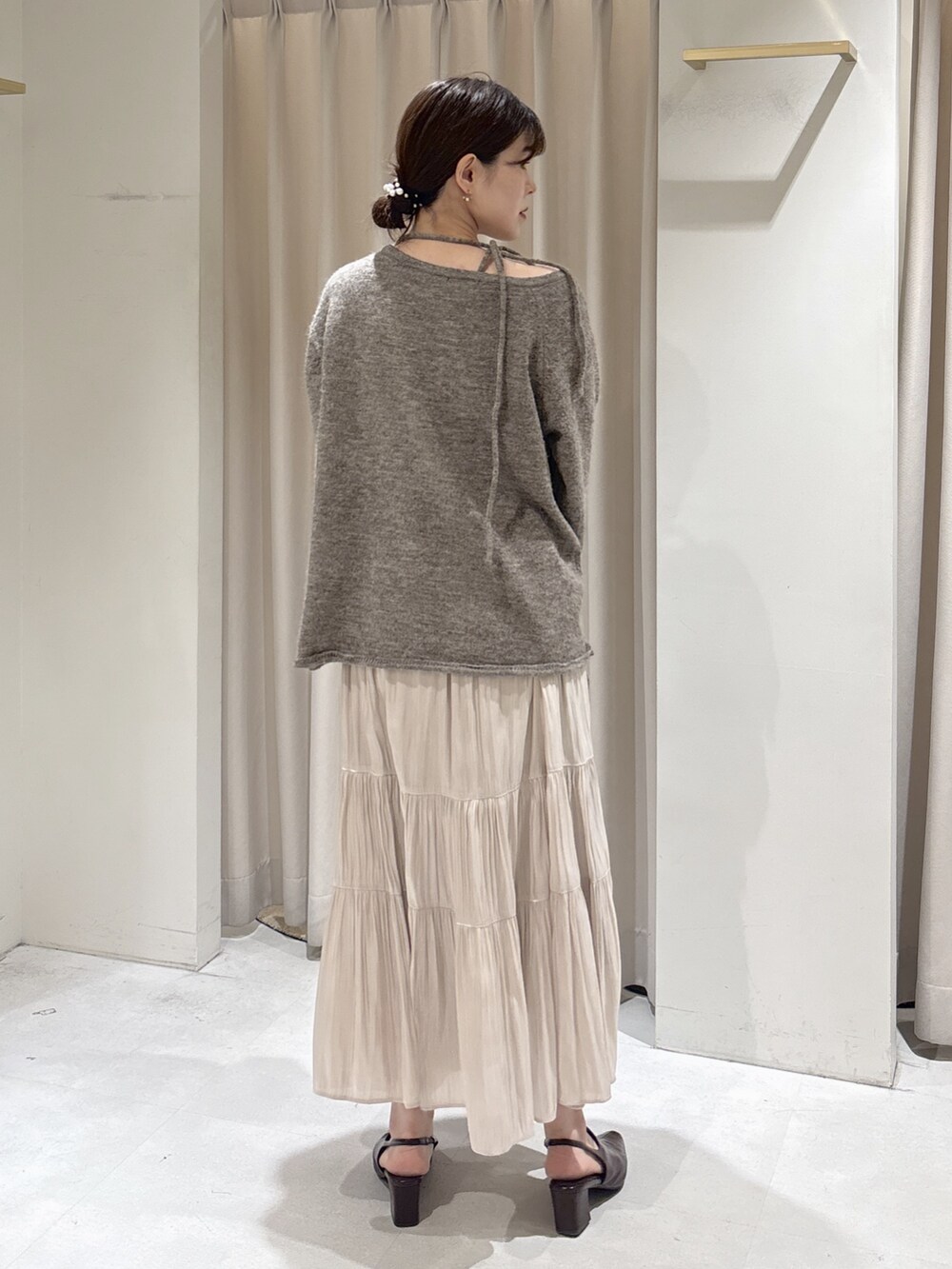 ブラウン系のニット/セーター、ホワイト系のスカート、ブラウン系のパンプスを着用したレディースの冬コーディネートの4枚目の写真