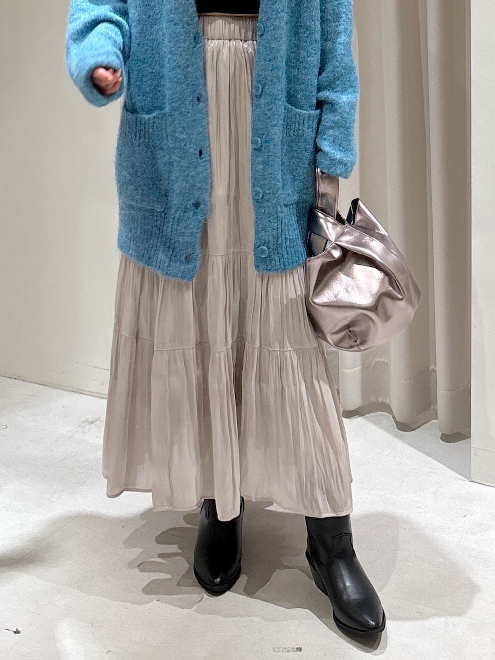 ブルー系のカーディガン/ボレロ、ブラック系のキャミソール、ホワイト系のスカートを着用したレディースの秋コーディネートの6枚目の写真