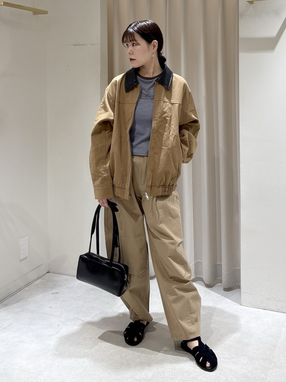 ブルー系のTシャツ/カットソー、ベージュ系のその他パンツ、ブラック系のショルダーバッグを着用したレディースの春コーディネートの4枚目の写真