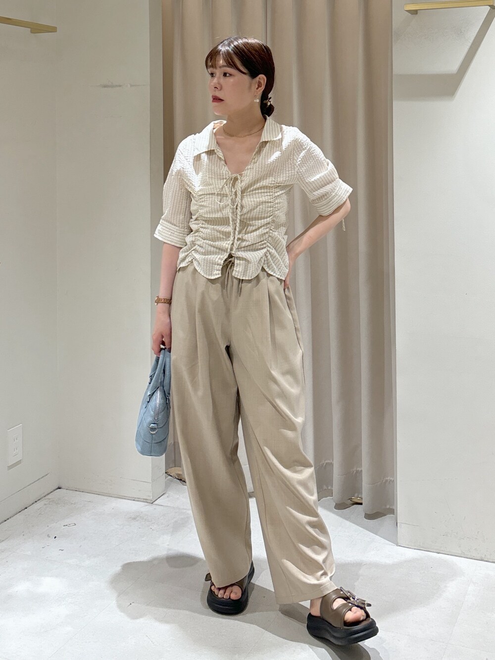 ベージュ系のその他パンツ、ブルー系のトートバッグ、ブラウン系のサンダルを着用したレディースの夏コーディネートの7枚目の写真