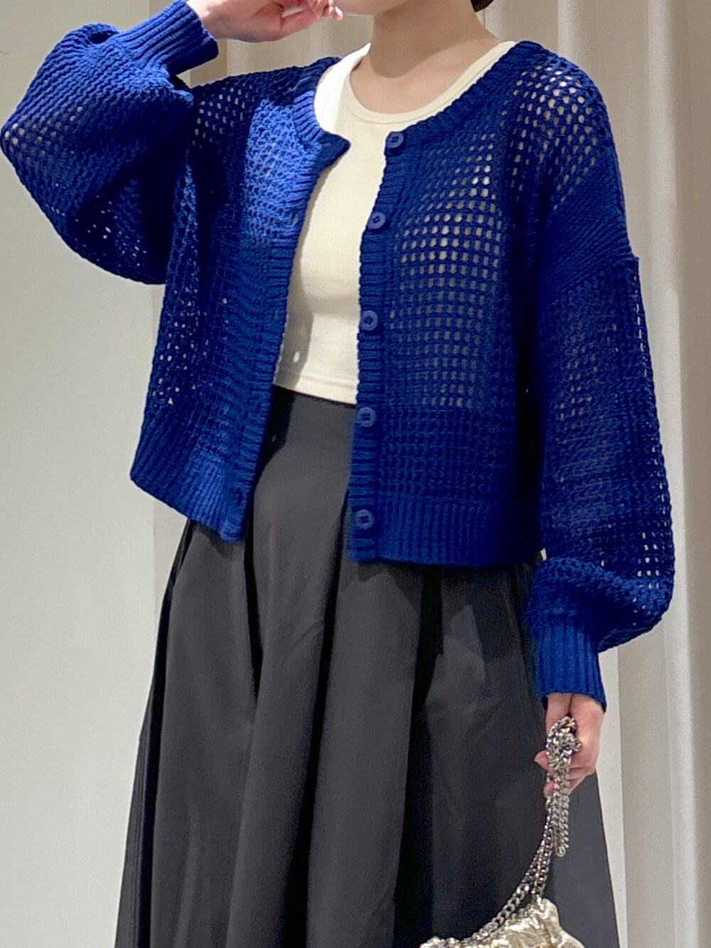 ブルー系のカーディガン/ボレロ、ホワイト系のタンクトップ、グレー系のスカートを着用したレディースの春コーディネートの6枚目の写真