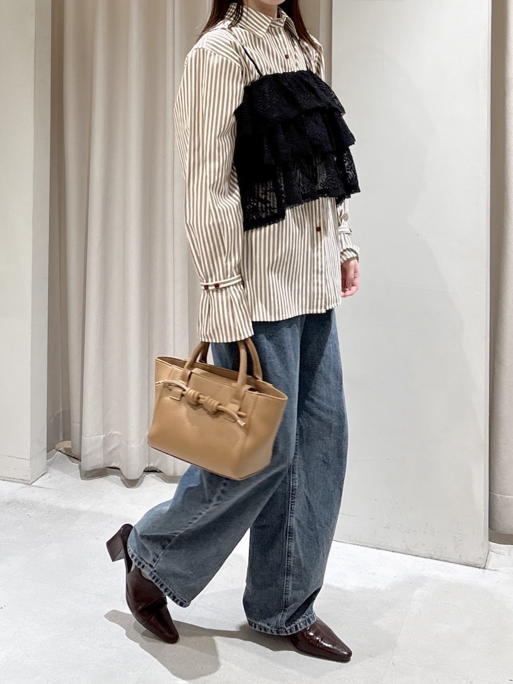 ブラック系のシャツ/ブラウス、ブラウン系のシャツ/ブラウス、ベージュ系のハンドバッグを着用したレディースの冬コーディネートの8枚目の写真