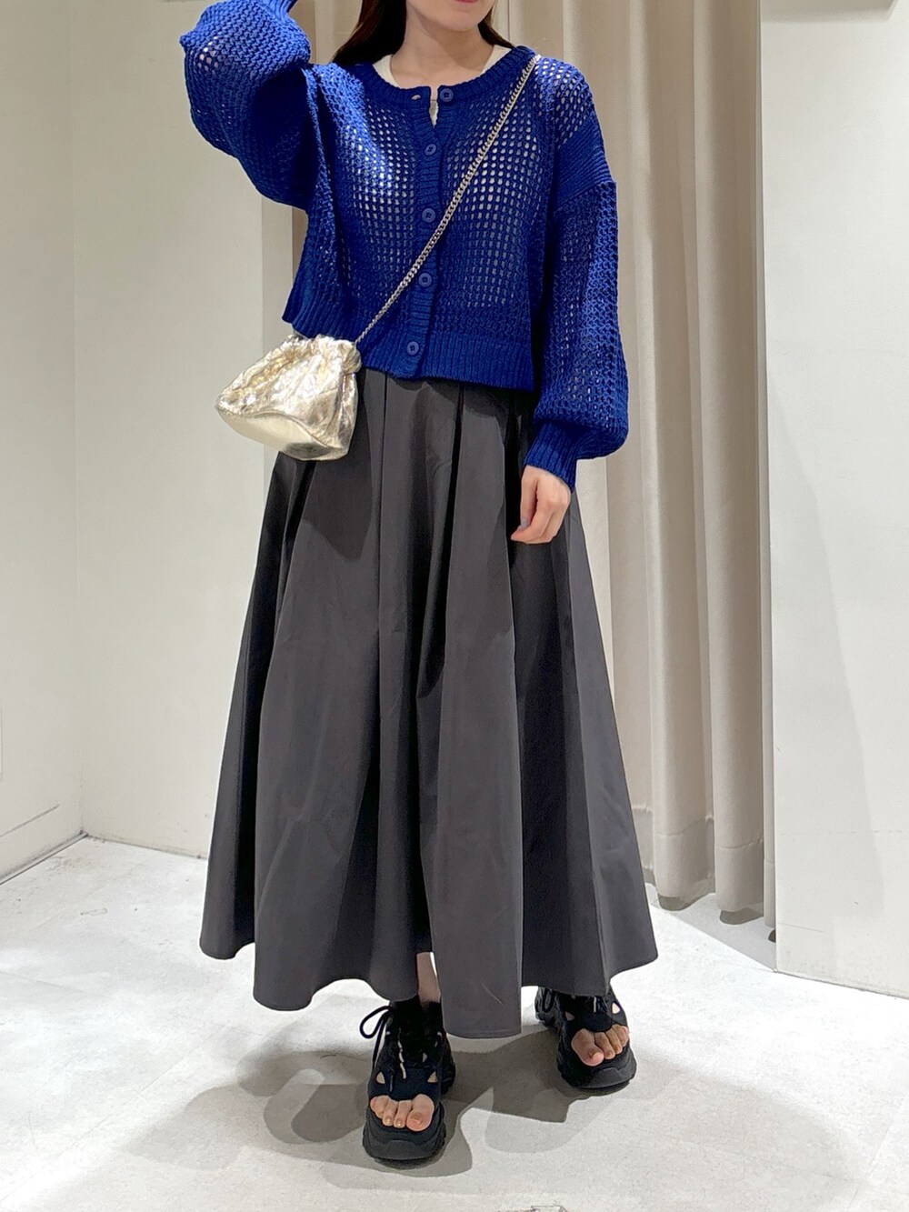 ブルー系のカーディガン/ボレロ、ホワイト系のタンクトップ、グレー系のスカートを着用したレディースの春コーディネートの3枚目の写真