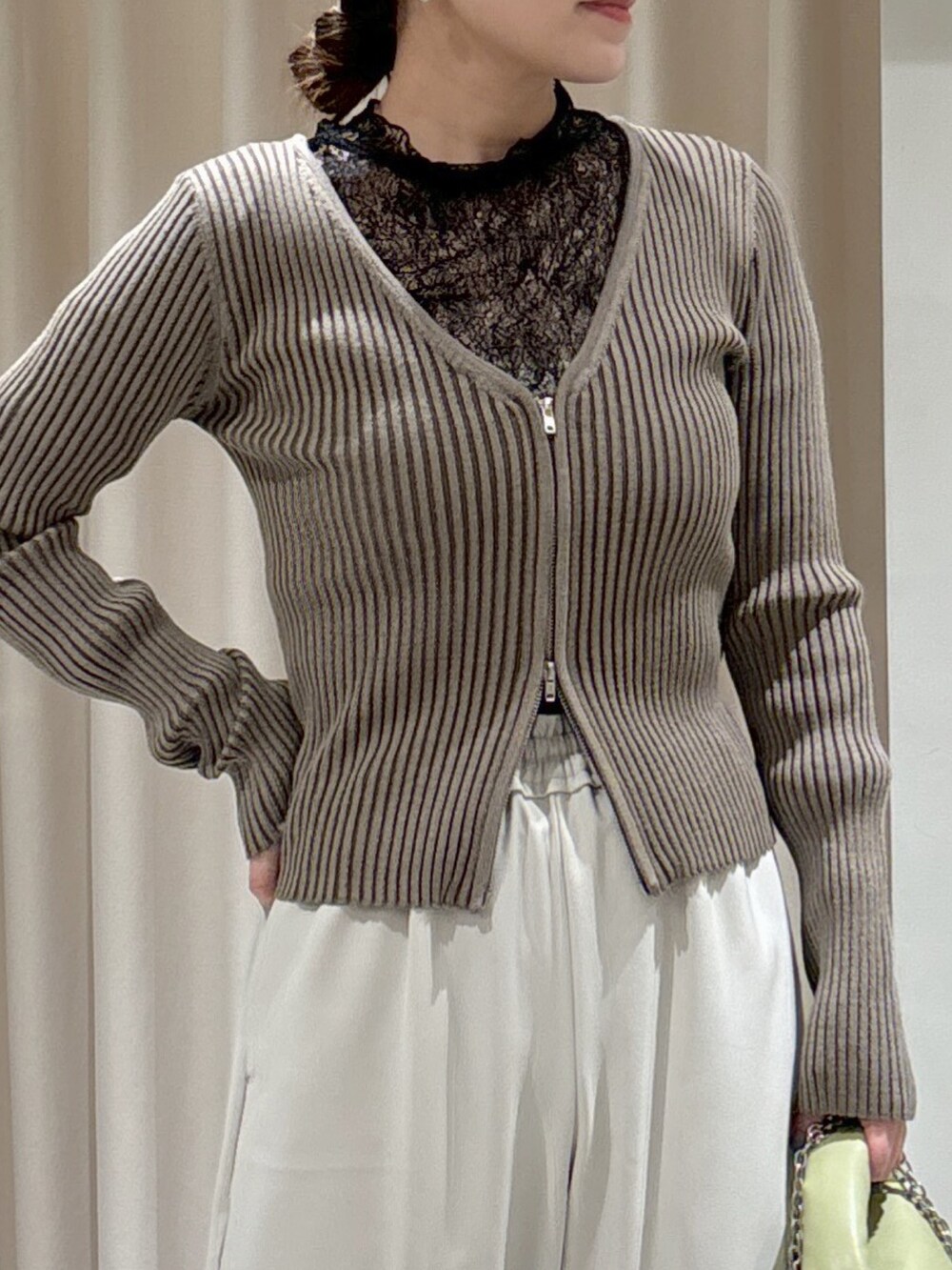 グリーン系のニット/セーター、ブラック系のTシャツ/カットソー、ホワイト系のキャミソールを着用したレディースの冬コーディネートの3枚目の写真