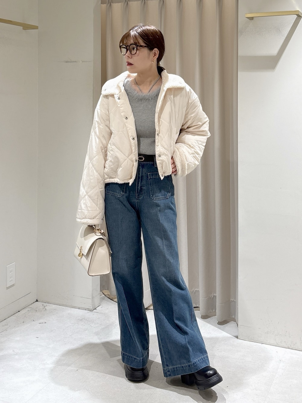 グレー系のニット/セーター、ブルー系のデニムパンツ、ホワイト系のトートバッグを着用したレディースの秋コーディネートの8枚目の写真