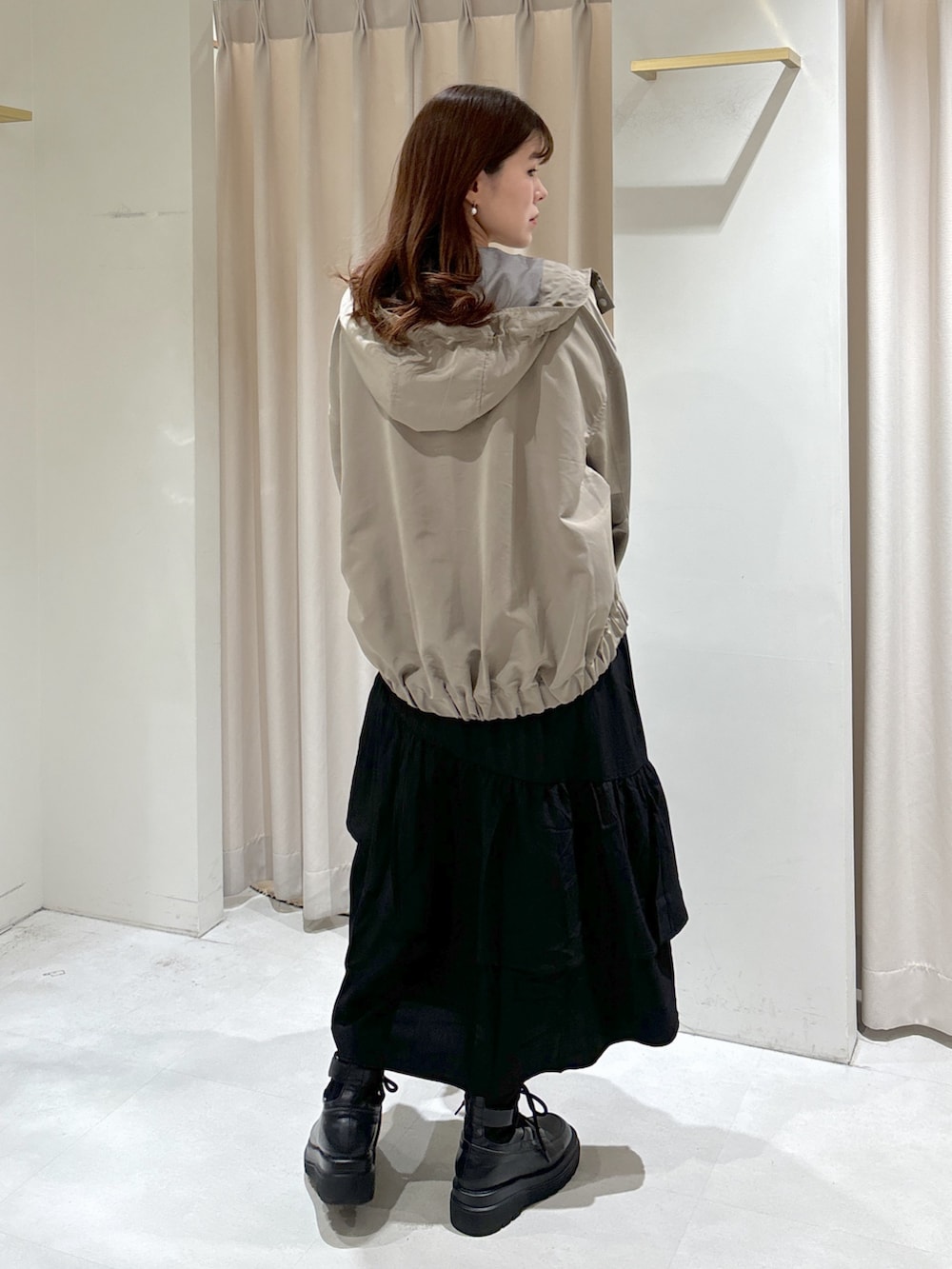 グリーン系のマウンテンパーカー、ブラック系のワンピース、ブラック系のブーツを着用したレディースの冬コーディネートの3枚目の写真