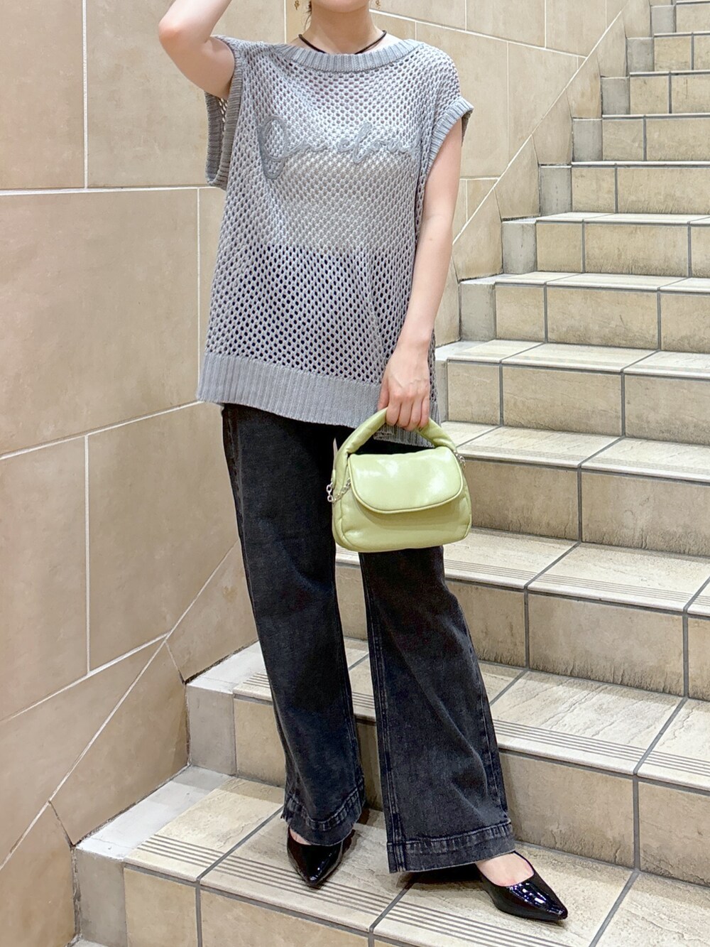 グレー系のニット/セーター、ホワイト系のキャミソール、グリーン系のショルダーバッグを着用したレディースの夏コーディネートの9枚目の写真