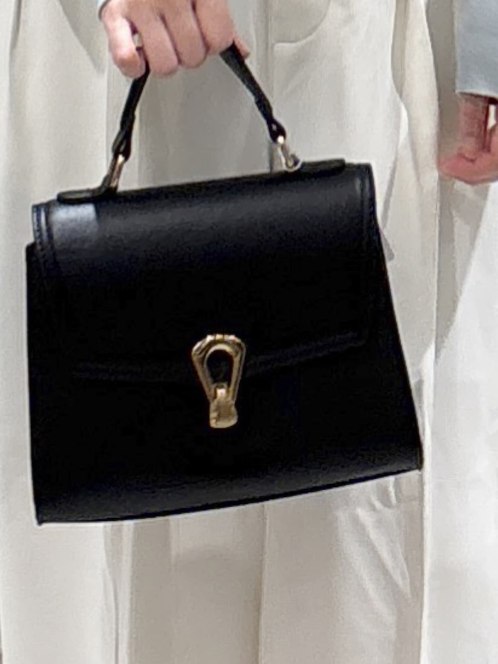 ブルー系のカーディガン/ボレロ、ホワイト系のその他パンツ、ブラック系のトートバッグを着用したレディースの秋コーディネートの4枚目の写真