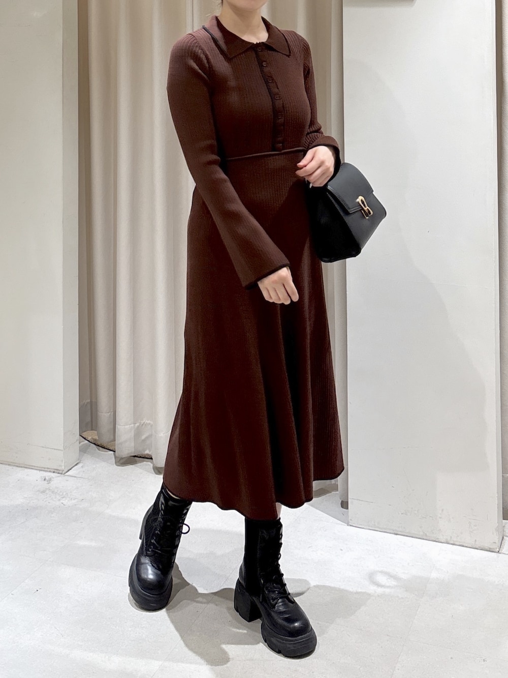 ブラウン系のワンピース、ブラック系のトートバッグ、ブラック系のブーツを着用したレディースの秋コーディネートの3枚目の写真