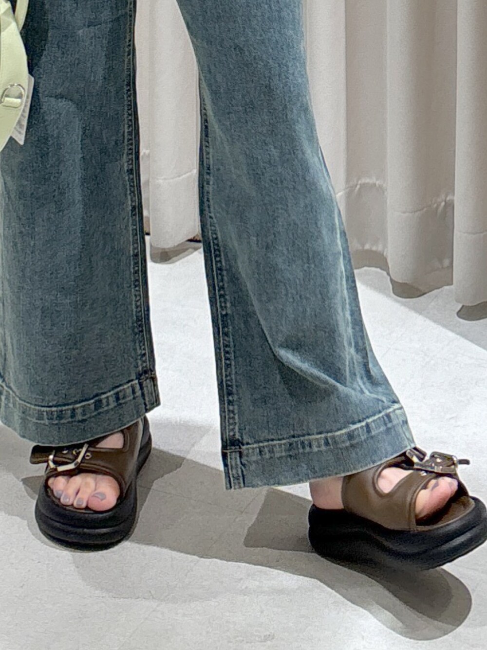 レッド系のポロシャツ、ブラック系のキャミソール、グリーン系のトートバッグを着用したレディースの春コーディネートの5枚目の写真