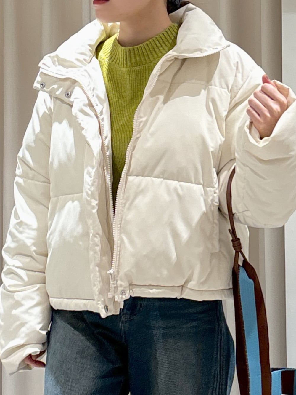 ホワイト系のブルゾン、グリーン系のニット/セーター、ブラウン系のショルダーバッグを着用したレディースの冬コーディネートの7枚目の写真