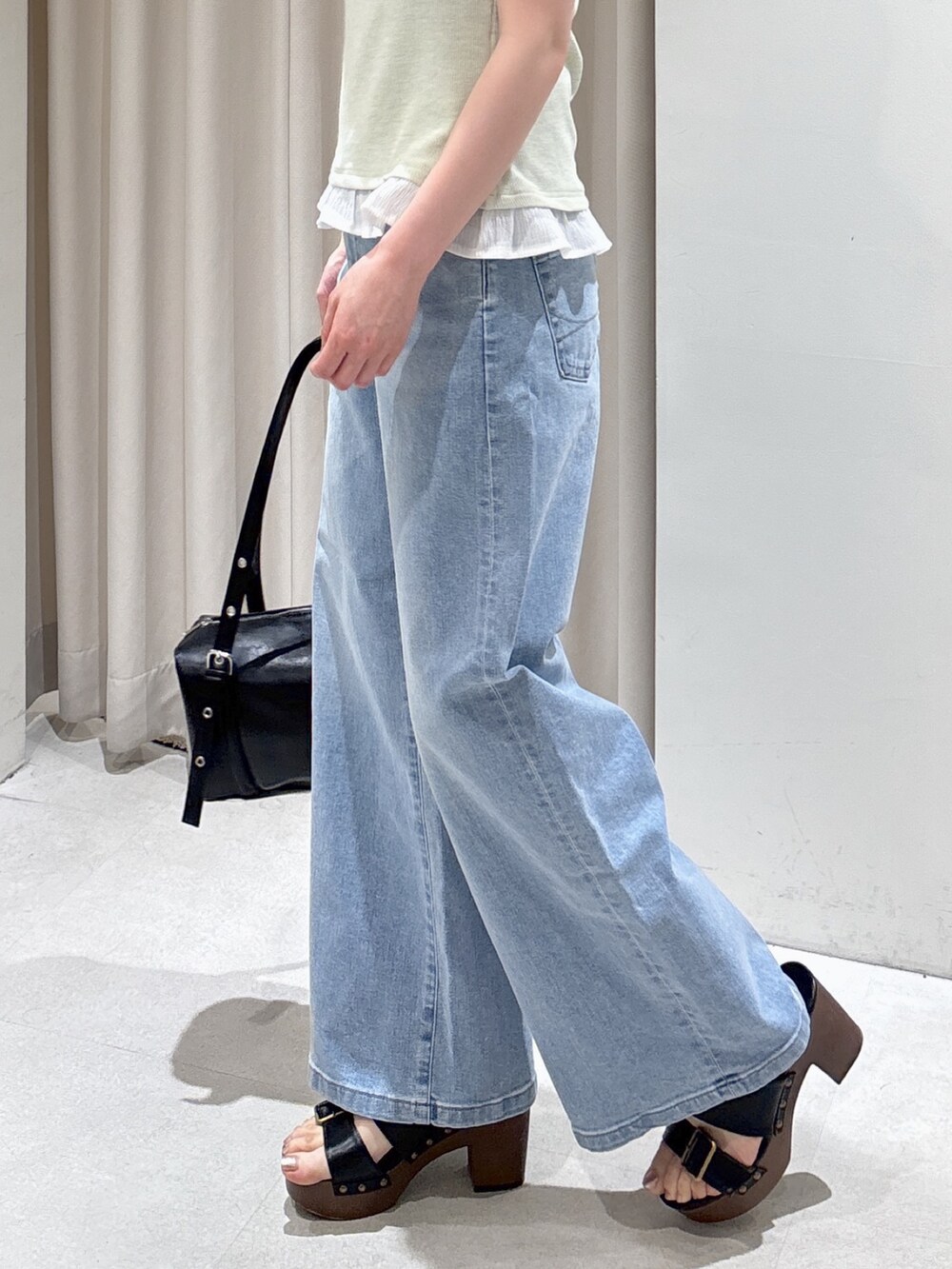 ベージュ系のテーラードジャケット、グリーン系のTシャツ/カットソー、ブルー系のデニムパンツを着用したレディースの春コーディネートの6枚目の写真