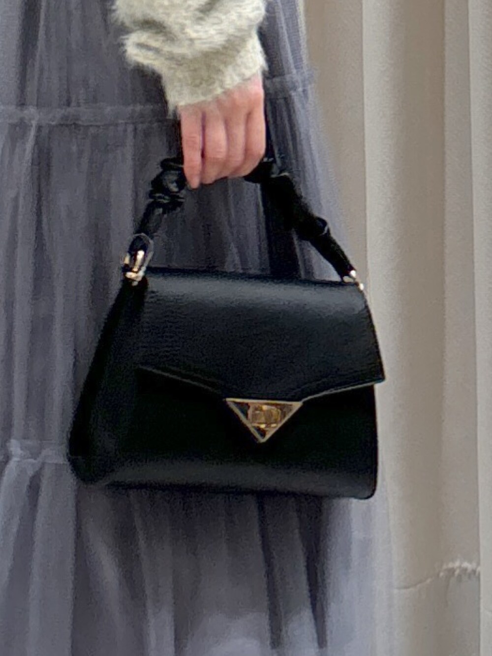 ブラック系のダウンジャケット/コート、グレー系のスカート、ブラック系のブーツを着用したレディースの秋コーディネートの9枚目の写真