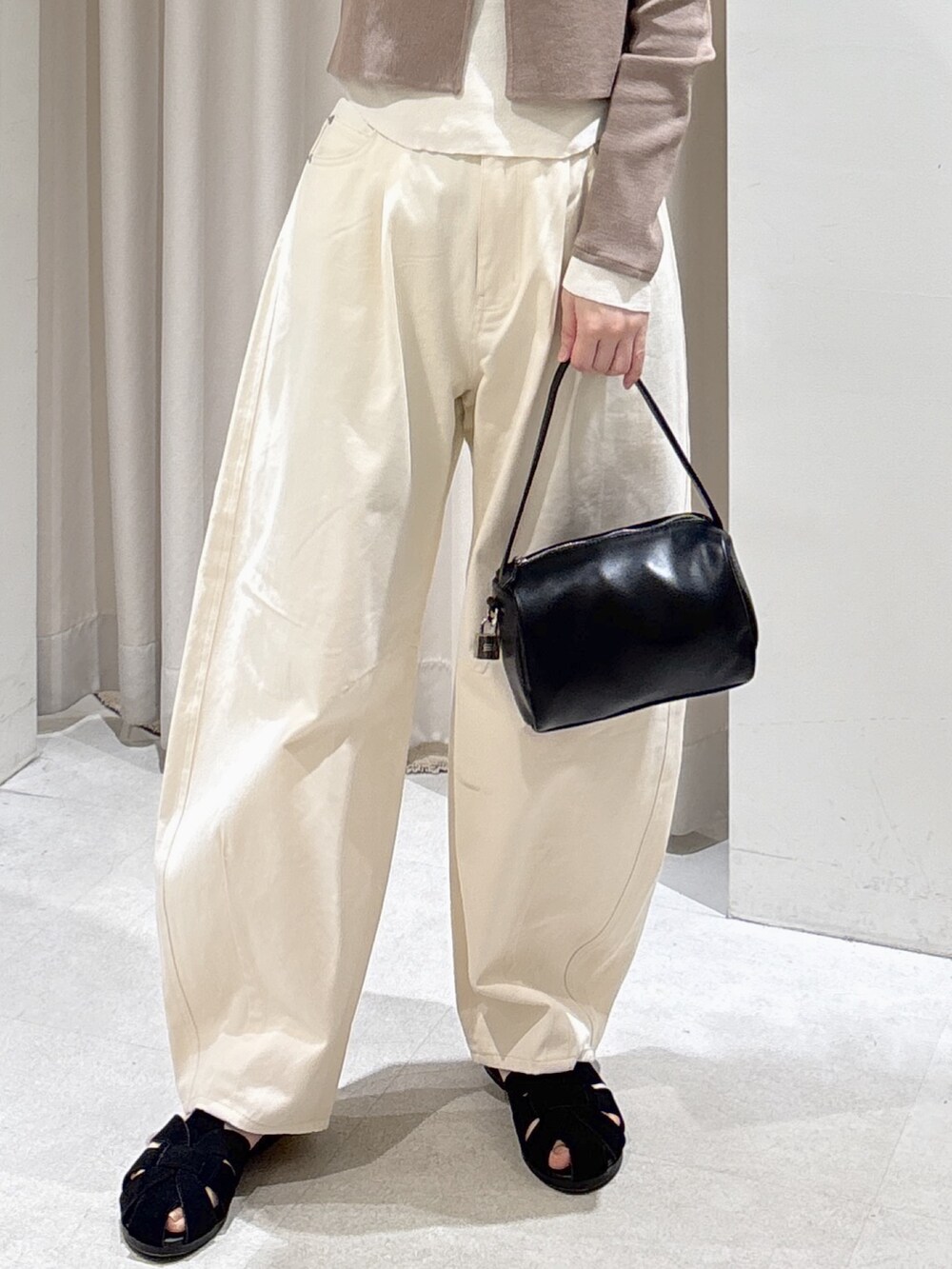 ブラウン系のニット/セーター、ホワイト系のその他パンツ、ブラック系のサンダルを着用したレディースの春コーディネートの6枚目の写真