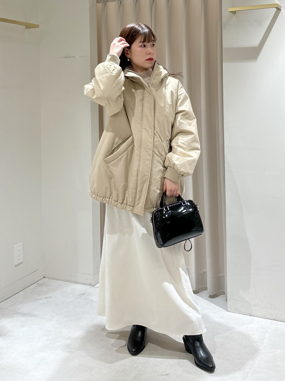 ホワイト系のTシャツ/カットソー、ブラック系のショルダーバッグ、ホワイト系のスカートを着用したレディースの冬コーディネートの8枚目の写真