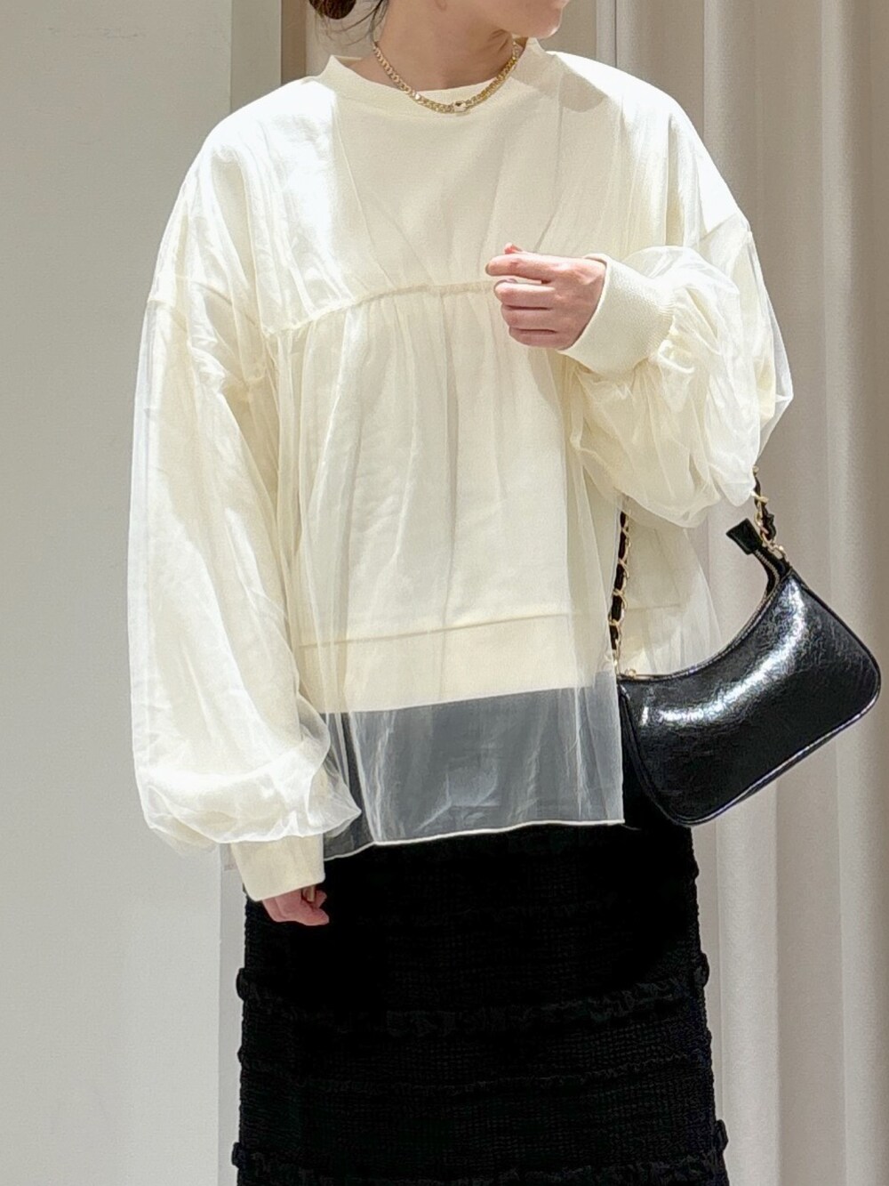 ホワイト系のスウェット、ブラック系のスカート、ブラック系のトートバッグを着用したレディースの秋コーディネートの2枚目の写真