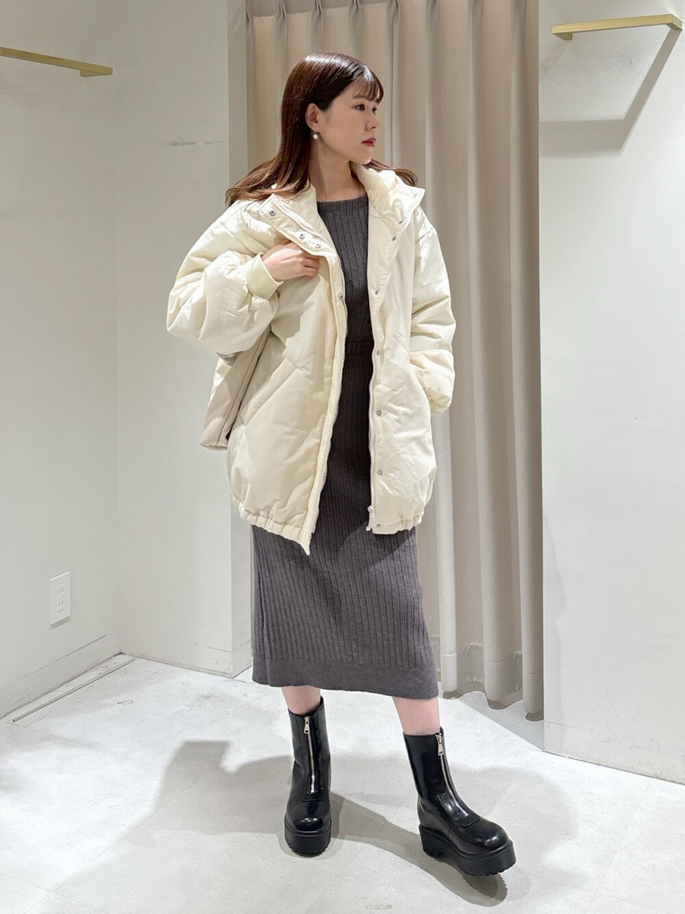 ホワイト系のブルゾン、グレー系のワンピース、ホワイト系のトートバッグを着用したレディースの冬コーディネートの2枚目の写真