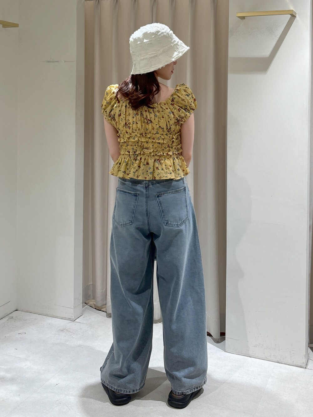 イエロー系のシャツ/ブラウス、ブルー系のトートバッグ、ブルー系のデニムパンツを着用したレディースの夏コーディネートの3枚目の写真