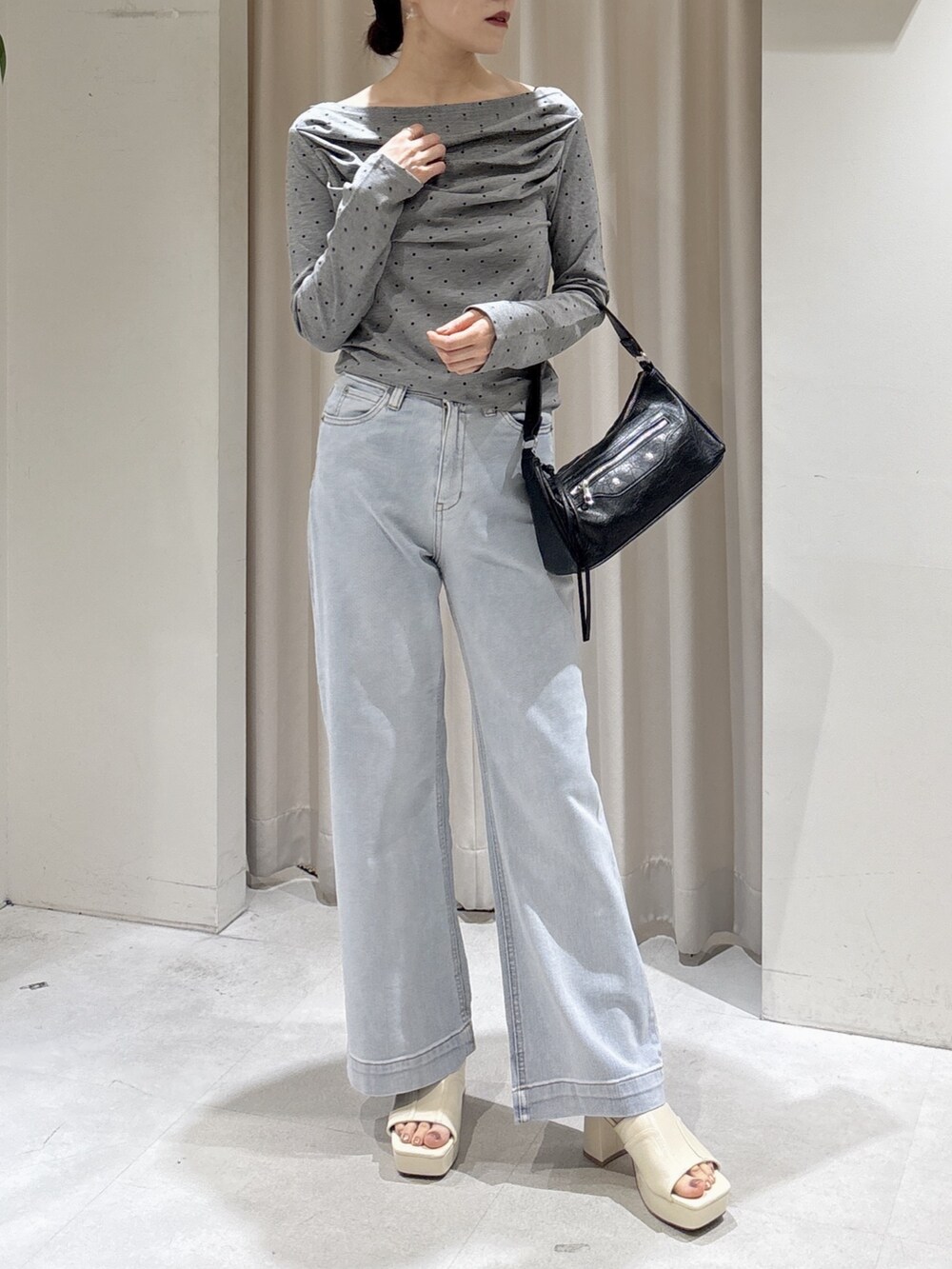 ブルー系のデニムパンツ、ブラック系のショルダーバッグ、ホワイト系のサンダルを着用したレディースの夏コーディネートの5枚目の写真