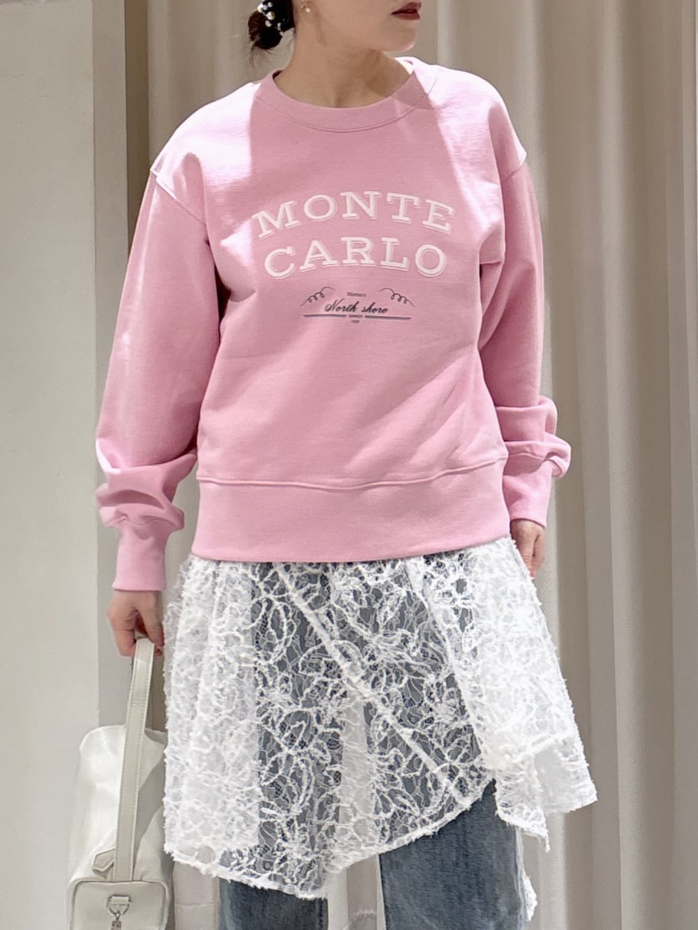 ピンク系のスウェット、ホワイト系のスカート、ブルー系のデニムパンツを着用したレディースの冬コーディネートの5枚目の写真