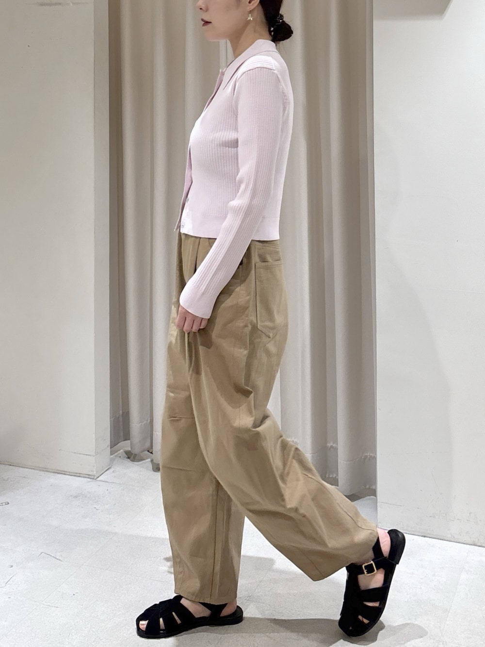 ピンク系のニット/セーター、ベージュ系のその他パンツ、ホワイト系のハンドバッグを着用したレディースの春コーディネートの3枚目の写真