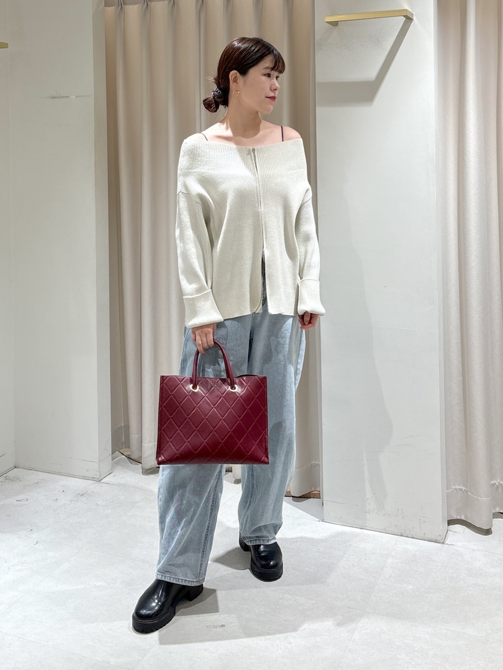 ホワイト系のニット/セーター、レッド系のショルダーバッグ、ブルー系のデニムパンツを着用したレディースの冬コーディネートの6枚目の写真