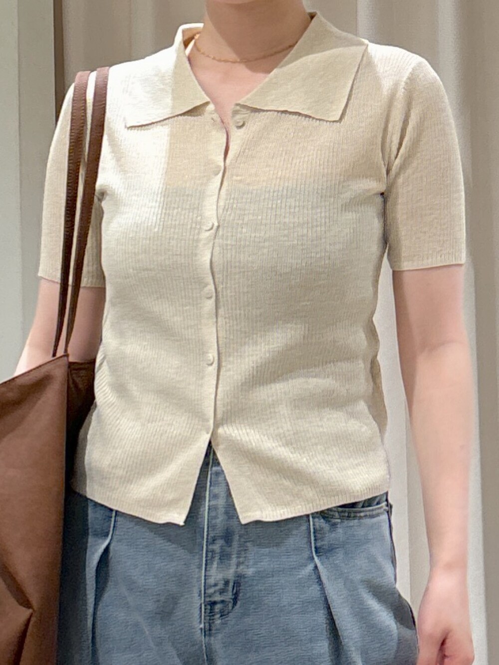 ブルー系のデニムパンツ、ブラウン系のサンダル、ブラック系のキャミソールを着用したレディースの春コーディネートの5枚目の写真