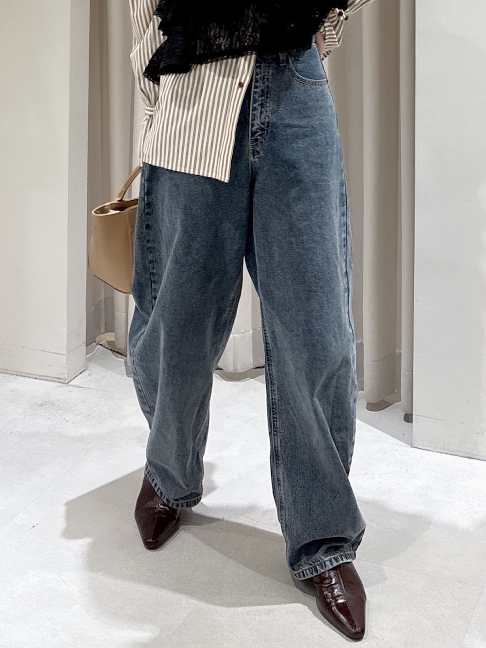 ブラック系のシャツ/ブラウス、ブラウン系のシャツ/ブラウス、ベージュ系のハンドバッグを着用したレディースの冬コーディネートの7枚目の写真