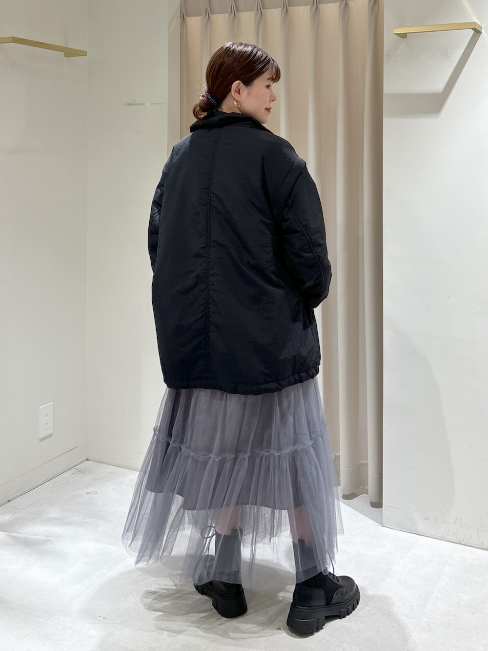 ブラック系のダウンジャケット/コート、グレー系のスカート、ブラック系のブーツを着用したレディースの秋コーディネートの5枚目の写真