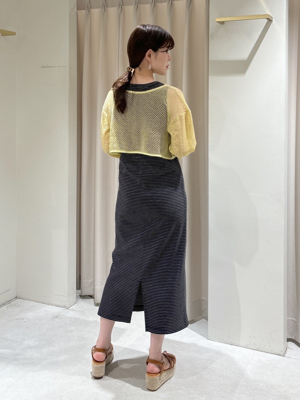 イエロー系のカーディガン/ボレロ、ブラック系のワンピース、ホワイト系のショルダーバッグを着用したレディースの夏コーディネートの3枚目の写真