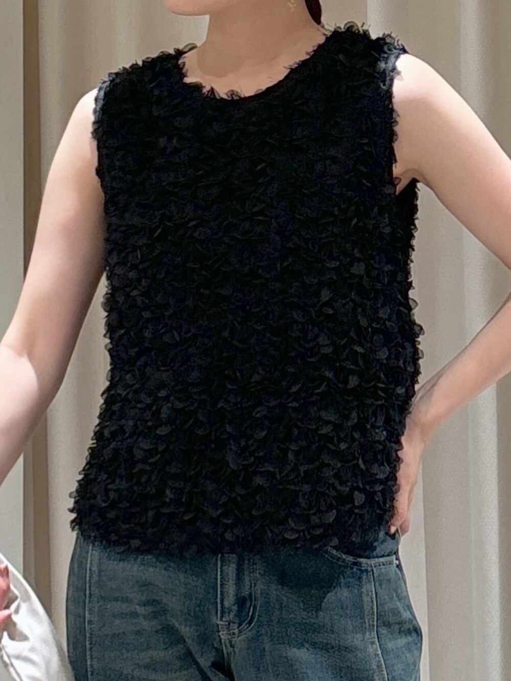 ブラック系のシャツ/ブラウス、ホワイト系のハンドバッグ、ブルー系のデニムパンツを着用したレディースの秋コーディネートの3枚目の写真